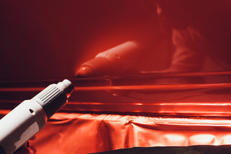 Car wrapping specialist putting vinyl foil or film on car. Selective focus.の写真素材