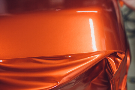 Car wrapping specialist putting vinyl foil or film on car. Selective focus.の写真素材