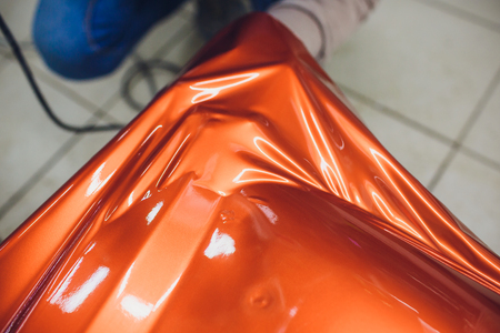 Car wrapping specialist putting vinyl foil or film on car. Selective focus.の写真素材