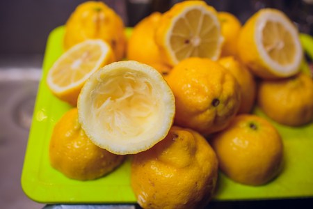 A close-up picture of bartender's hands cutting a raw, ripe and fresh green lime on cutting desk. Exotic fruity beverage preparation composition.の写真素材