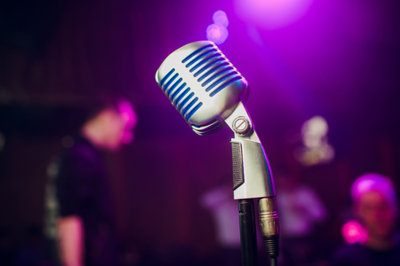 A modern microphone for singing against a beautiful blurry colored bokeh.の写真素材