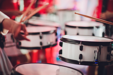 Vintage toned live music background, drummer plays with drumsticks on rock drum set. Closeup photo with soft selective focusの写真素材