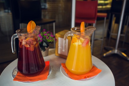 two glass jars of home made fresh raspberry lemonade or virgin mojito cocktail with a straw on the tableの写真素材