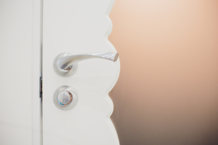 Detail of a metallic knob on white door horizontalの写真素材