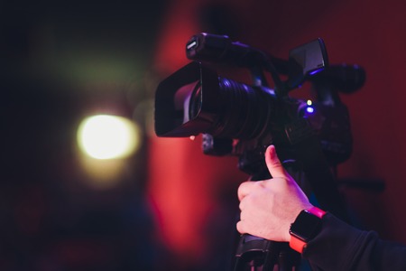 hands holding a movie clapper and a vintage movie cameraの写真素材