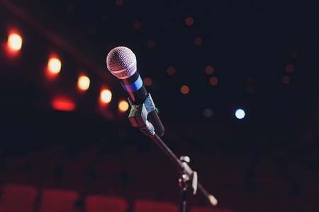 microphone on a background of red hall with seating for spectatorsの写真素材