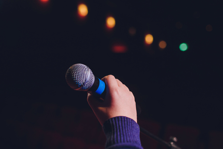 microphone on a background of red hall with seating for spectatorsの写真素材
