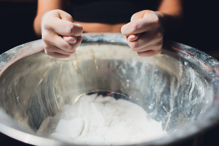 Cropped shot of young female athlete clapping hands with chalk powder before strength trainingの写真素材