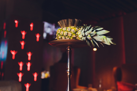 Exotic hookah. Different hookah over the bright backgrounds with smoke. Hookah with fruit flavour on wooden table in vintage styleの写真素材