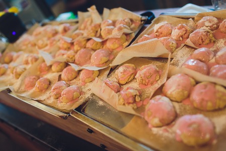 Coconut cupcakes in silicone forms close-up. Baking molds filled by raw sweet dough in flower, star or circle shape. Yummy shortbread pastries on wood background. Making of Xmas and New Year cookiesの写真素材
