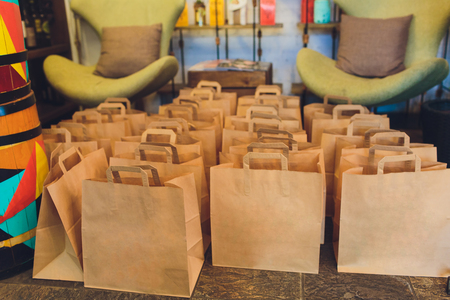 Crafted christmas presents wrapped in paper bags with wooden clips in red and white colors with sewing suppliesの写真素材