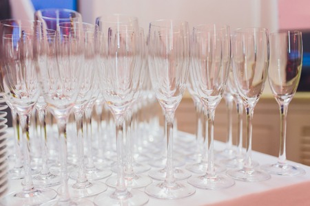Crystal clear empty wine glasses on the table. Alcohol background. A lot of wine glasses at the barの写真素材
