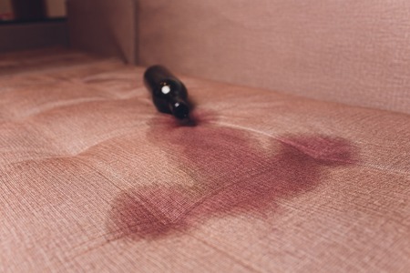 Red wine spilled on a brown couch sofa dark bottle of red wine droppedの写真素材