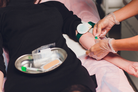 the doctor collects blood in a syringe, Nurse takes blood from the veins on the armの写真素材