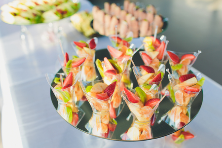 Beautifully vibrant view of decorated catering banquet table with different food snacks and appetizers on corporate christmas birthday party event or wedding celebrationの写真素材
