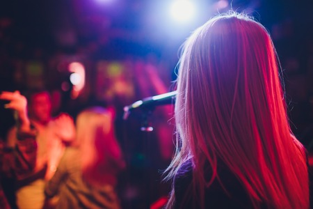 Entertianment at a wedding. A female singer is interacting with the crowd while a man plays an acoustic guitar.の写真素材