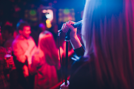 Entertianment at a wedding. A female singer is interacting with the crowd while a man plays an acoustic guitar.の写真素材