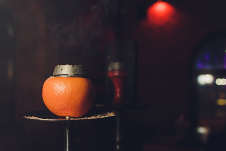 Luxury hookah with orange. Exotic bowl with fruit. Hookah lounge. Fruits and coals. Glamours relax. Narghile and water pipe.の写真素材