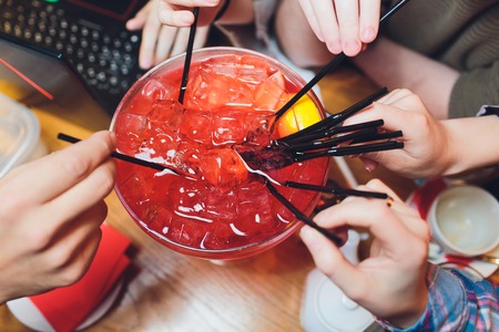 Happy friends enjoying summer party outdoor drinking extra large cocktail together-Young diverse...