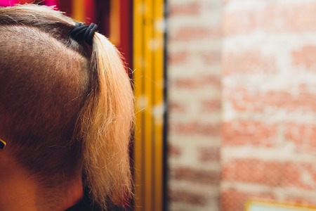 male haircut pigtail, close-up on a nature background. Photo of nape without faceの写真素材