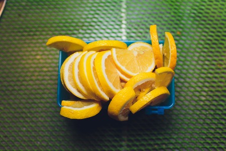 Woman slicing lemon on a plastic cutting board in the kitchen