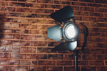 Lighting equipment one lamp lit, on brick.