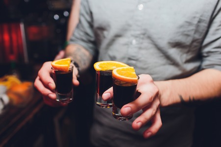 Shots cocktails with orange hand male.の写真素材