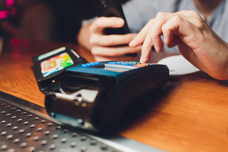 Woman hand with credit card swipe through terminal for sale in restaurantの写真素材