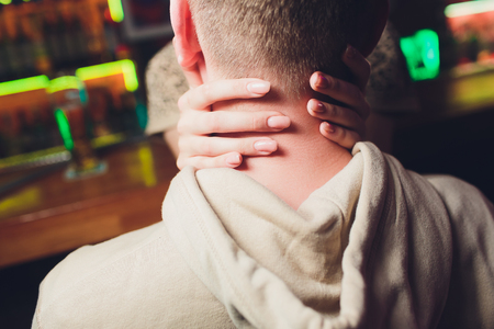 Women's arms around a man's head on a dateの写真素材