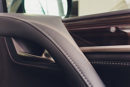 Car inside. Interior of prestige modern car. Climate control, hi-end sound speakers, seat memory, door lever side mirror. White cockpit with wood metal decoration blue ambient lightの写真素材