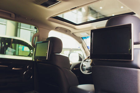 Car inside. Interior of prestige luxury modern car. Three TV displays for passenger with media control panel copy space and mock upの写真素材