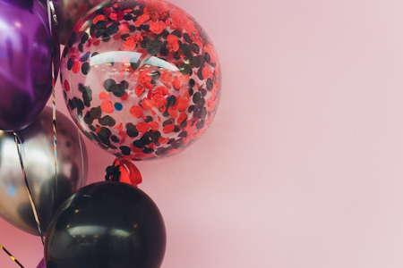 birthday and christmas concept - close up of colorful air balloons over brick wall backgroundの写真素材