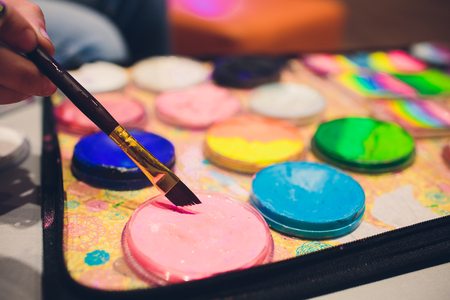 Artistic equipment: paint, brushes and art palette on wooden tableの写真素材