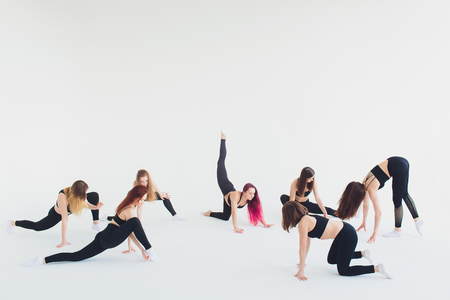 Fitness, stretching practice, group of two attractive happy smiling fit mature women working out in sports club, doing Extended Side Angle posture, utthita parshvakonasana pose in class, full length.の写真素材