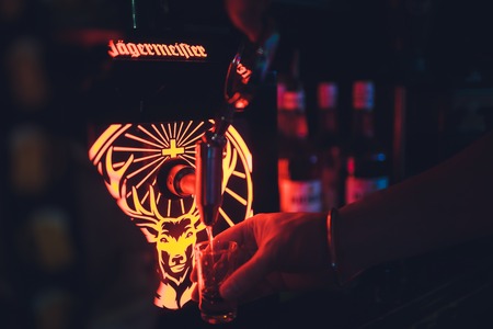 Ufa, Russia, HARATS PUB, 5 November, 2018: Jagermeister alcohol drinks in bar. bartender pours a glass.のeditorial素材