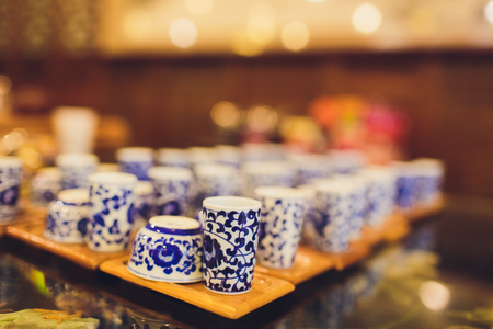 Teapot and cup of tea on woodensurface with blurry nature background.の写真素材