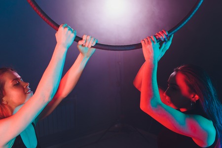 Aerial acrobat in the ring. A two young girl performs the acrobatic elements in the air ring.の写真素材