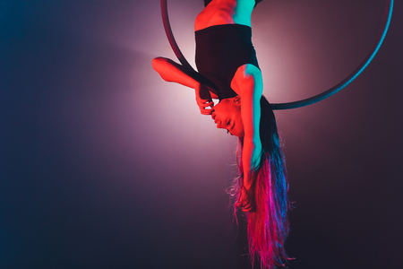 Aerial acrobat in the ring. A young girl performs the acrobatic elements in the air ring.の写真素材