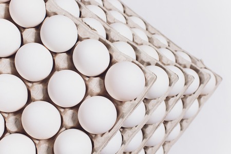 White eggs of a hen in harmless, cardboard packing on a white background. 5 packs.の写真素材