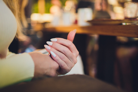 Close up on female hands folded in prayer at a wooden table.の写真素材