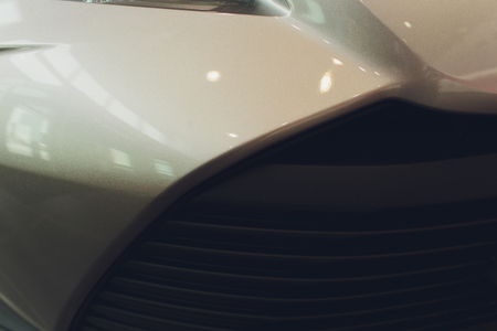 Grid of car with sunflare. Radiator grille. Metal close-up texture background. Chrome grill of big...