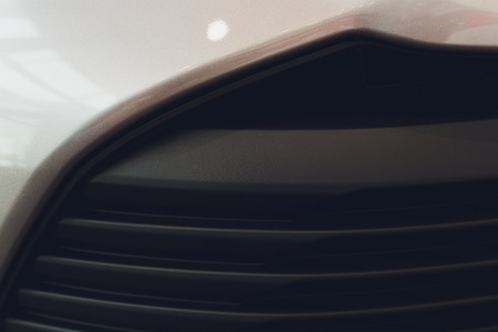 Grid of car with sunflare. Radiator grille. Metal close-up texture background. Chrome grill of big powerful engine macro.の写真素材