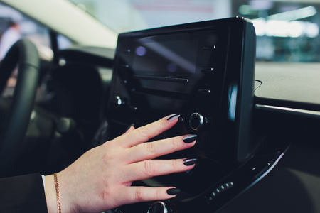 Transportation,technology and vehicle concept - man using car system control pushing panel button touch screen interface modern design,GPS and DVD ,Vintage color.の写真素材