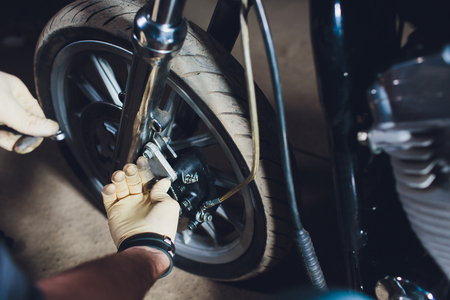 Man fixing bike. Confident young man repairing motorcycle near his garage.の写真素材