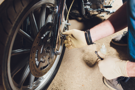 Man fixing bike. Confident young man repairing motorcycle near his garage.の写真素材