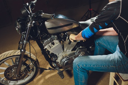 Man fixing bike. Confident young man repairing motorcycle near his garage.の写真素材