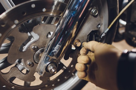 Man fixing bike. Confident young man repairing motorcycle near his garage.の写真素材