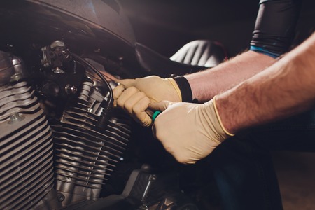 Man fixing bike. Confident young man repairing motorcycle near his garage.の写真素材
