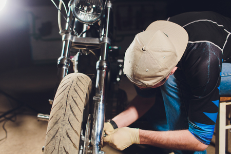 Man fixing bike. Confident young man repairing motorcycle near his garage.の写真素材