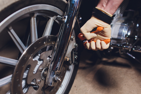 Man fixing bike. Confident young man repairing motorcycle near his garage.の写真素材